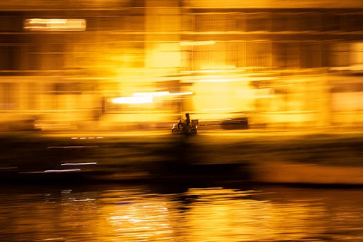 Dynamic long exposure capture of a scooter at night, featuring blurred city lights and reflections.
