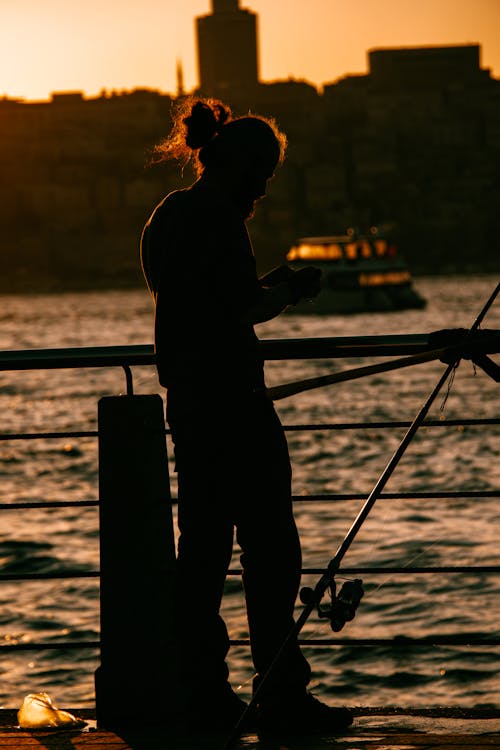 Silhouette of Fisherman in Town at Sunset