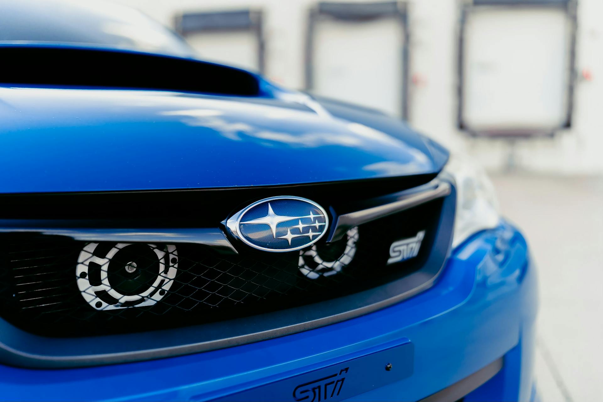 A detailed view of a blue Subaru car grille showcasing its logo and design elements.