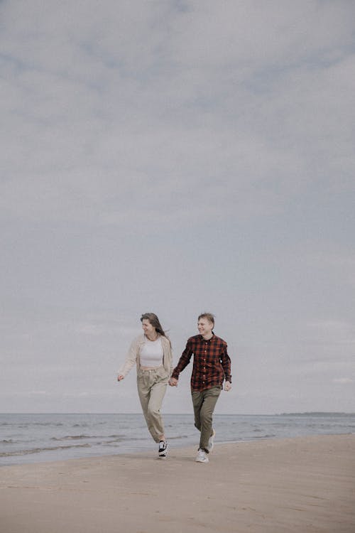 A Couple Walking on the Shore · Free Stock Photo