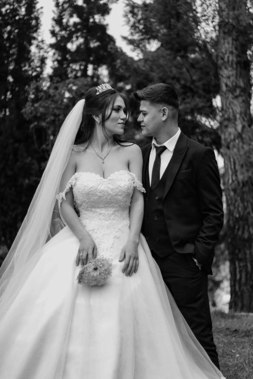 Free Elegant black and white portrait of a bride and groom captured outdoors, showcasing wedding fashion. Stock Photo