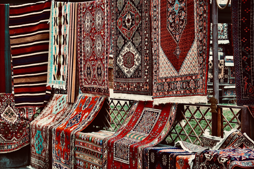 Free Colorful handmade rugs displayed at an outdoor market stall, showcasing intricate patterns and craftsmanship. Stock Photo