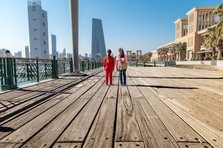 Girls Standing On Wooden Promenade In Kuwait