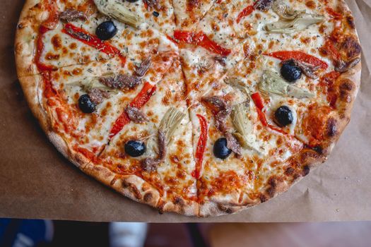Top View of a Pizza with Black Olives and Red Peppers
