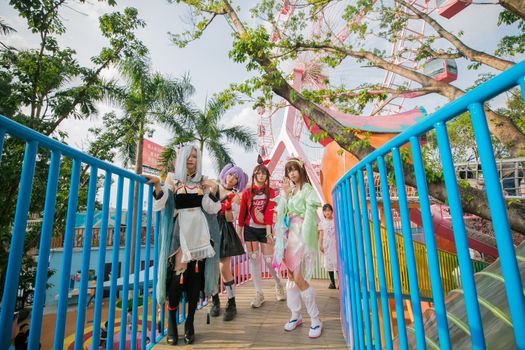 Colorful cosplay characters enjoying a lively day at an amusement park, embracing creativity and fun.