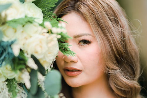 Blonde Woman Face behind Flowers