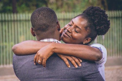 Woman Hugging a Man in Gray Suit Jacket