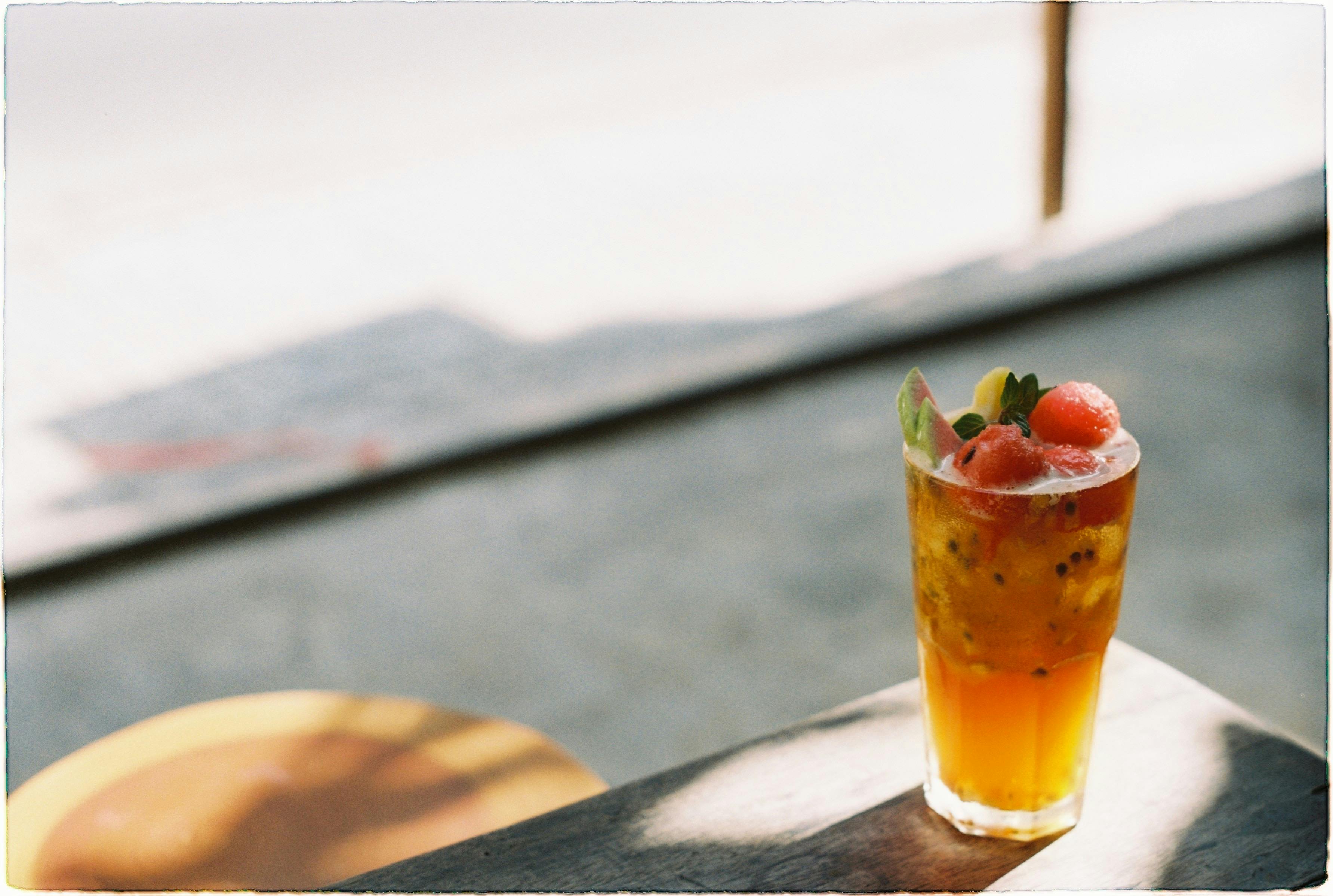 Vibrant fruit cocktail sitting on a sunlit table, perfect for a summer refreshment.