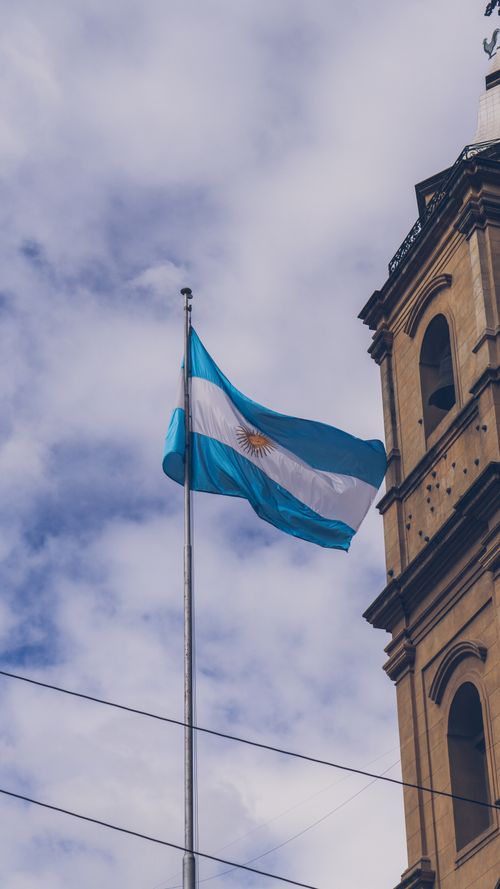 Free Low angle shot of the Argentinian flag near a historic building in Buenos Aires with an overcast sky. Stock Photo