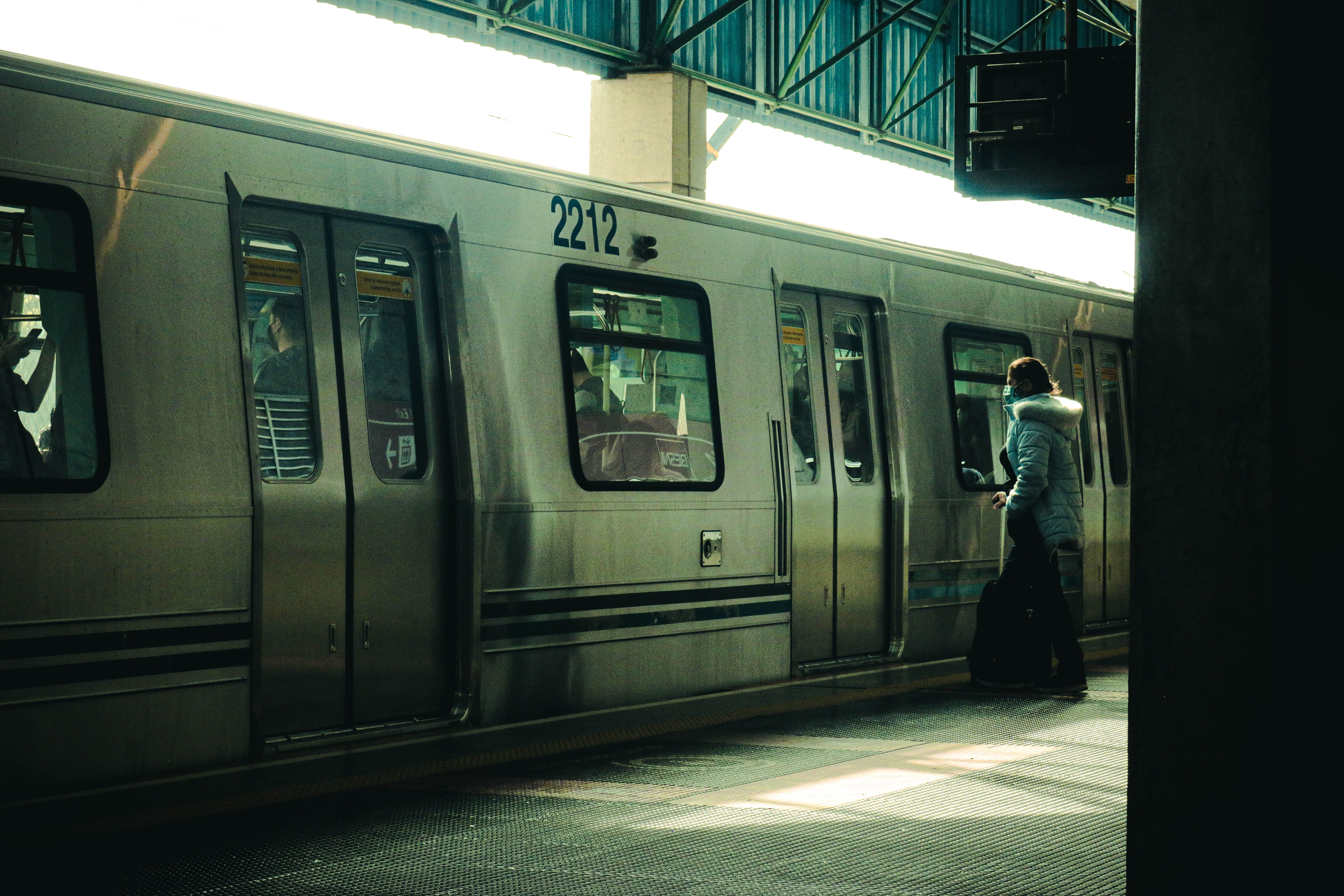 Person in coat boards subway train at metro station, embodying urban commute.