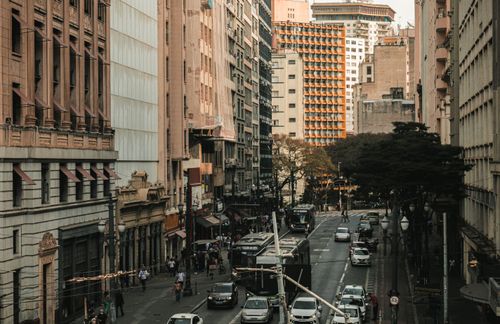 Free High-angle view of a bustling city street with cars and buses amidst tall buildings. Stock Photo