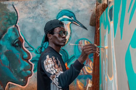 A man painting a vibrant street art mural in Nairobi, Kenya.