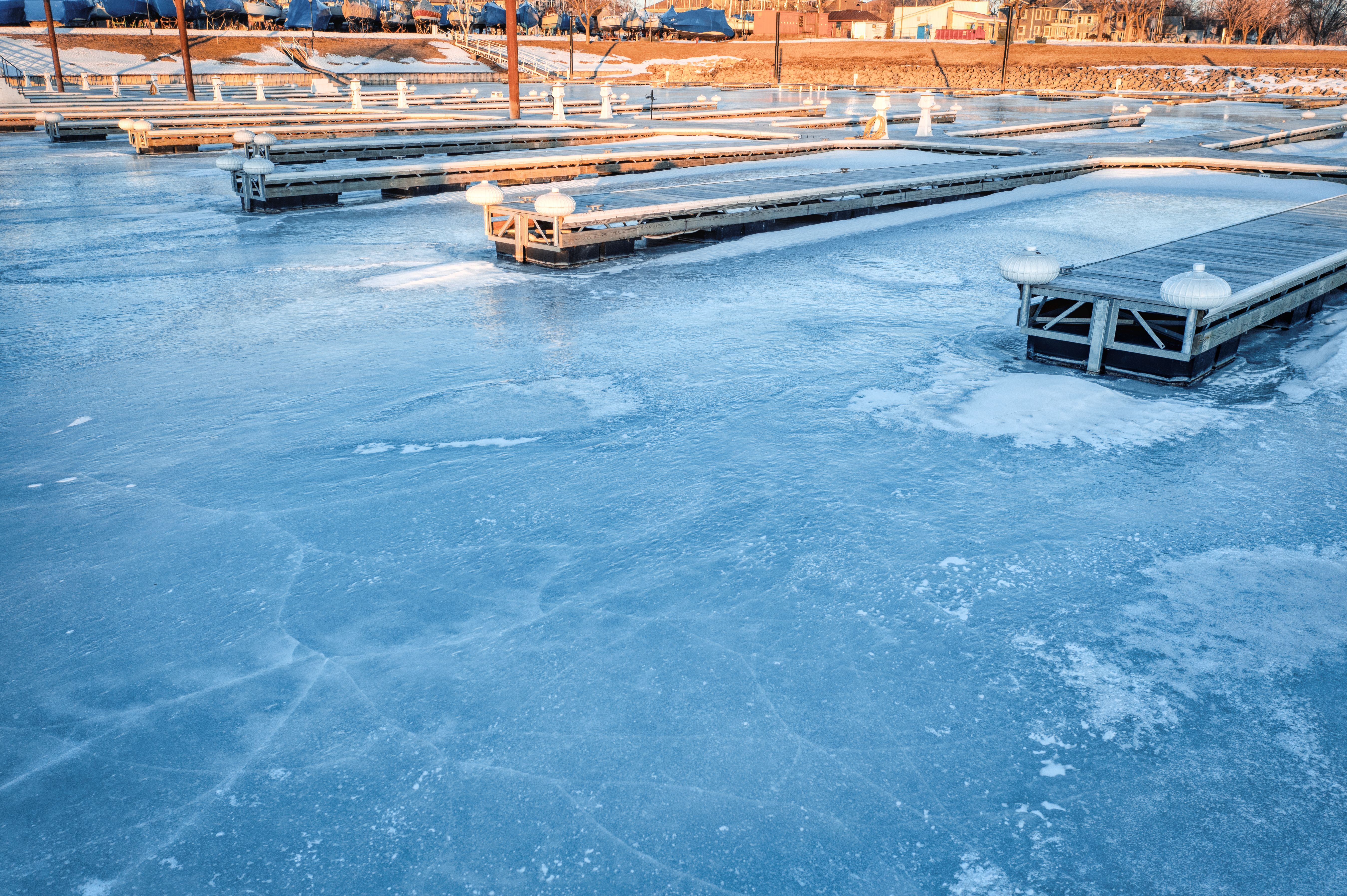 Aerial view of a frozen marina in Lake City, MN, showcasing icy piers and a winter landscape.