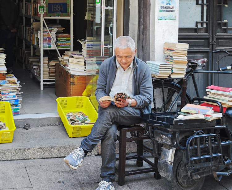 Man Sitting And Reading Book