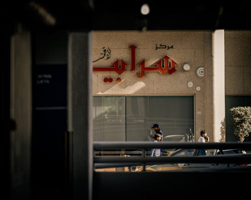 Pedestrians Walking in front of a Building in City 