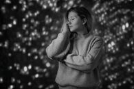 这幅肖像画宁静祥和，描绘了一位身着毛衣的女子，背景是柔和的散景，唤起了平静的沉思