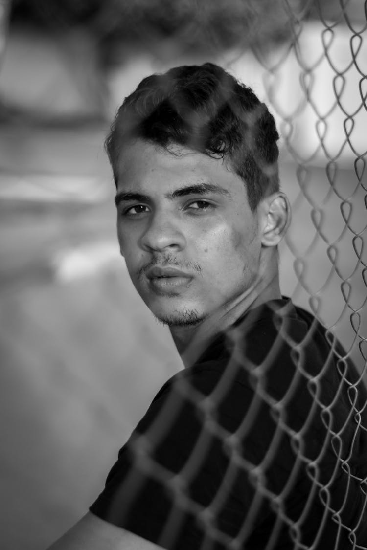 Man Posing Behind Net In Black And White