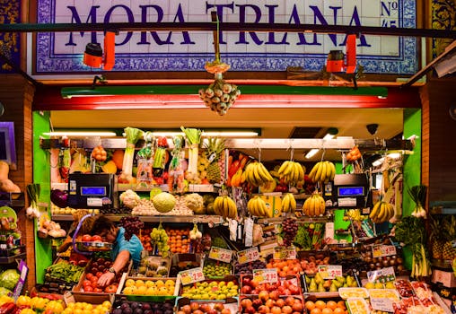 Colorful fruit stall in Triana Market, Seville, displaying a variety of fresh produce.