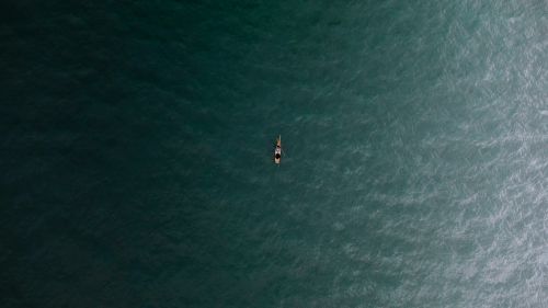 Free Drone shot of a canoe in the ocean near Huanchaco, showcasing tranquility and adventure. Stock Photo