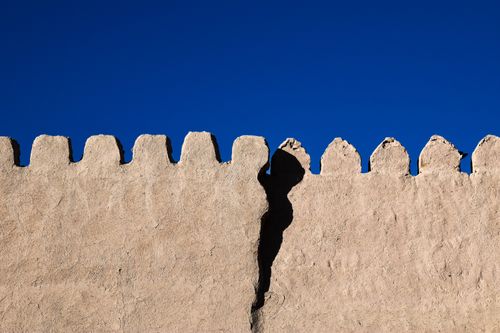 Free Ancient wall in Khiva, Uzbekistan, showcasing historic architecture and texture under a clear blue sky. Stock Photo