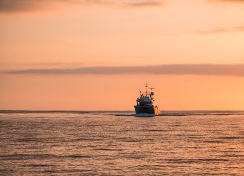 Ship Sailing on Sea at Sunset