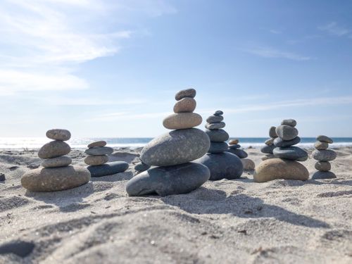 Free Stone towers on a sunlit beach, capturing tranquility and nature's balance. Stock Photo
