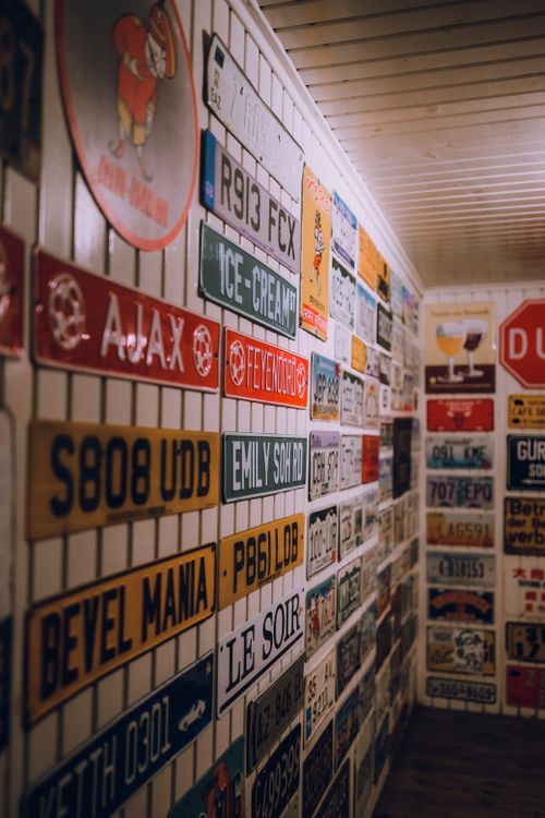 Free A wall decorated with an array of vintage and retro license plates in a cozy interior setting. Stock Photo