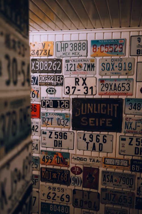 Free A collection of vintage license plates displayed on an interior wall with a retro aesthetic. Stock Photo