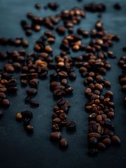 Roasted coffee beans scattered on a dark surface — photo by Navid Sohrabi on Pexels