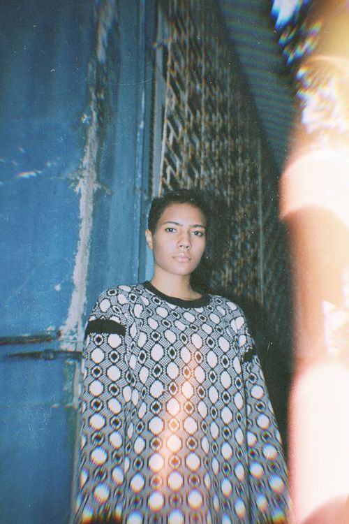 Free Vintage-style portrait of a woman indoors wearing a geometric sweater with soft light. Stock Photo