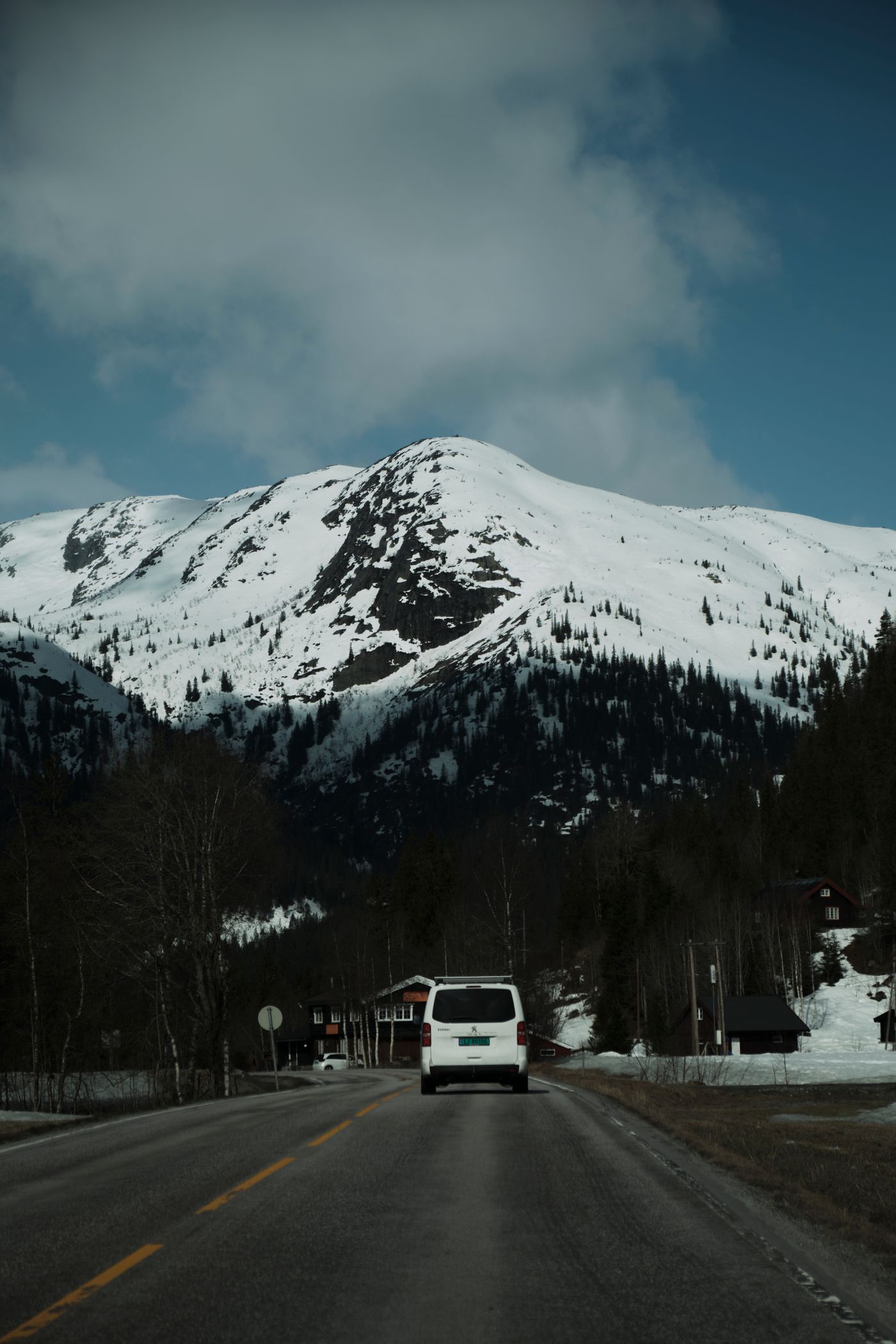 Autos fahren auf einer verschneiten Bergstraße in einer winterlichen Landschaft