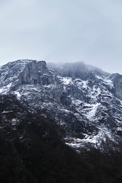 Rocky Snowcapped Mountain in Fog 