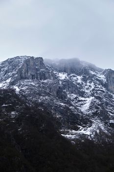 Scenic view of snowcapped Bondhus mountain peak in Vestland, Norway with overcast sky.