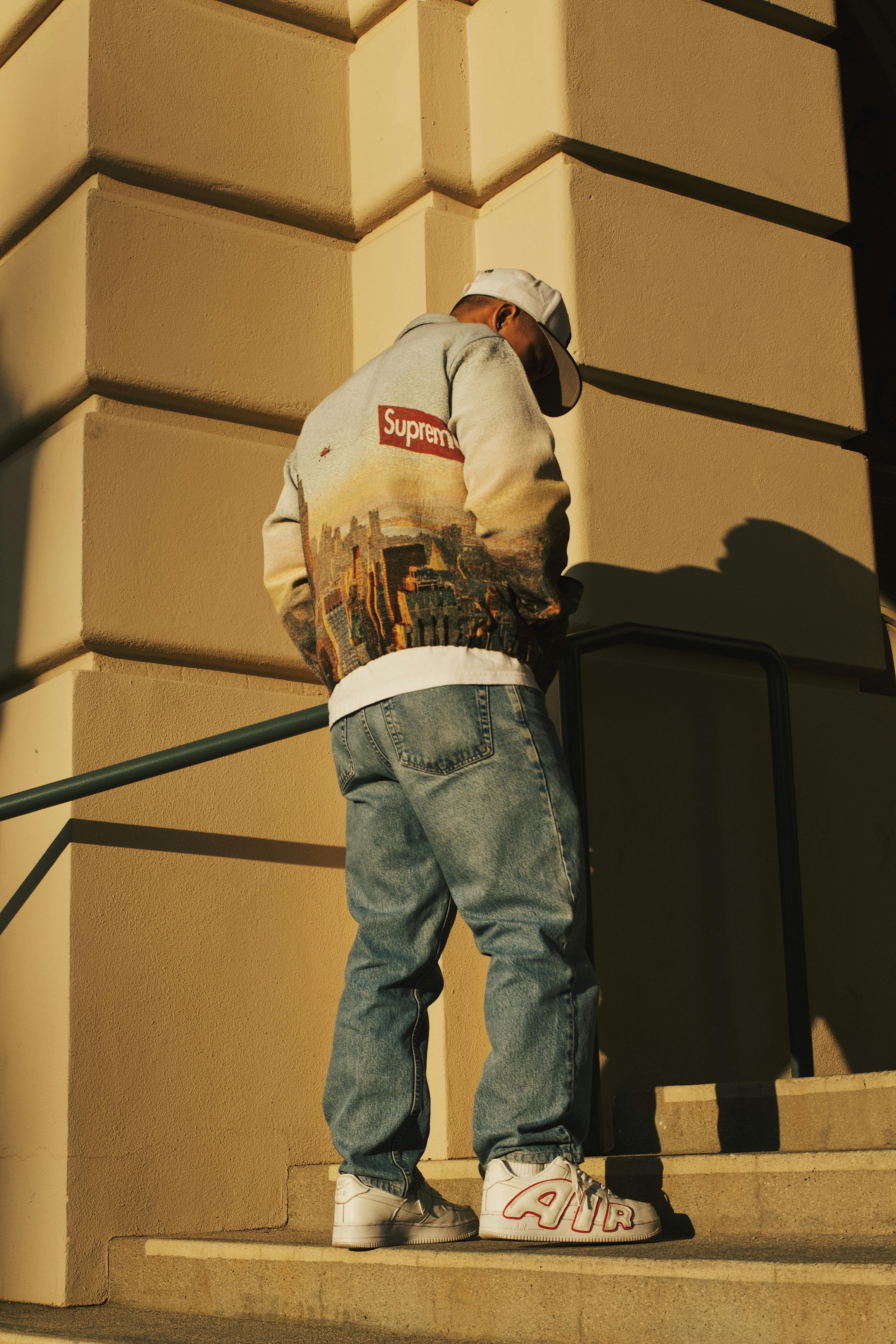 Man Wearing a Casual Trendy Outfit Standing on Steps in Sunlight