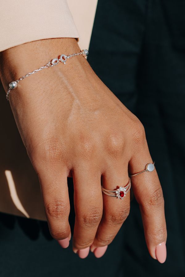 Close-up of a hand wearing a silver bracelet and rings