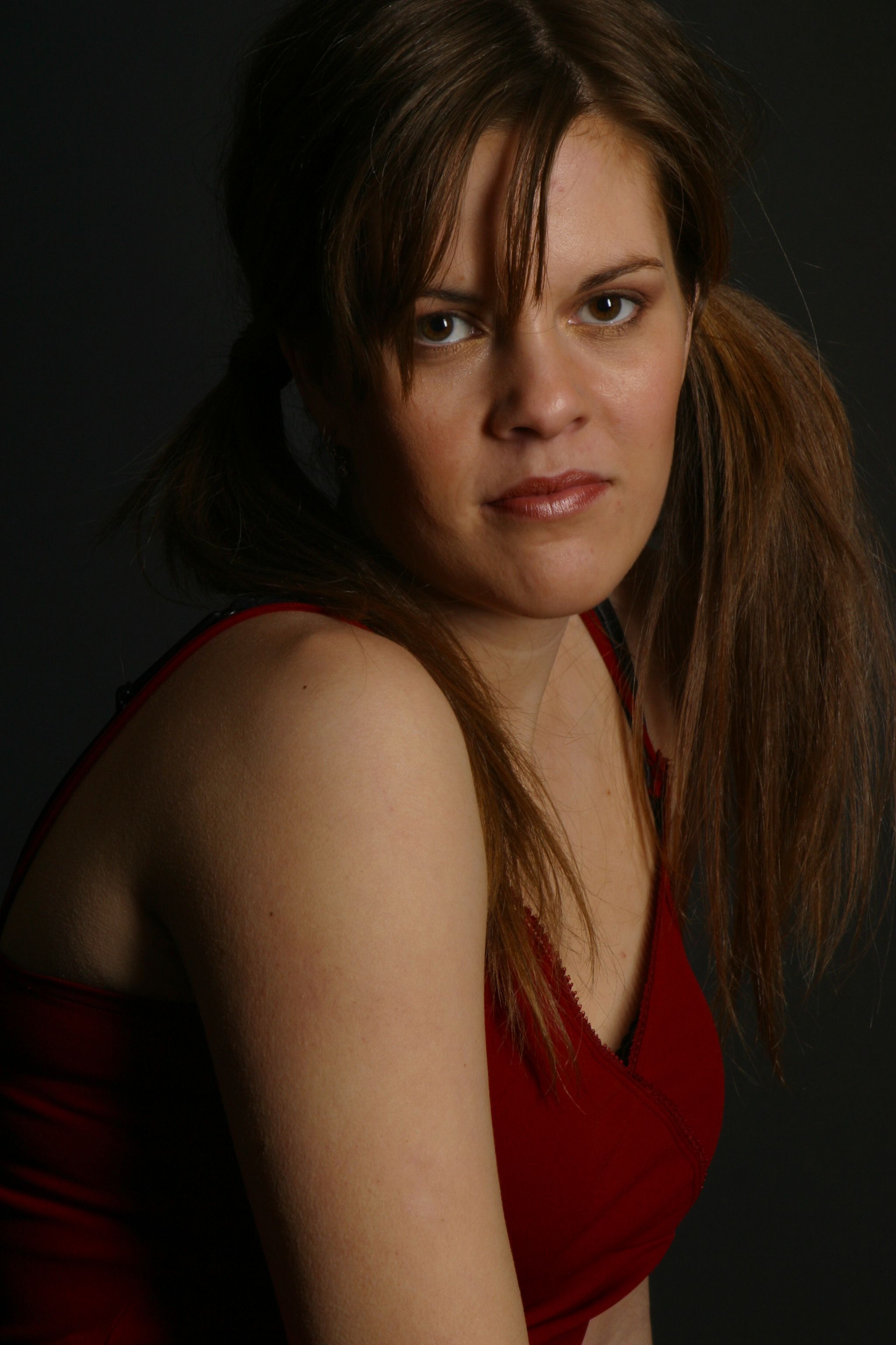 Stunning portrait of a young woman with brown hair in a stylish pose captured indoors.
