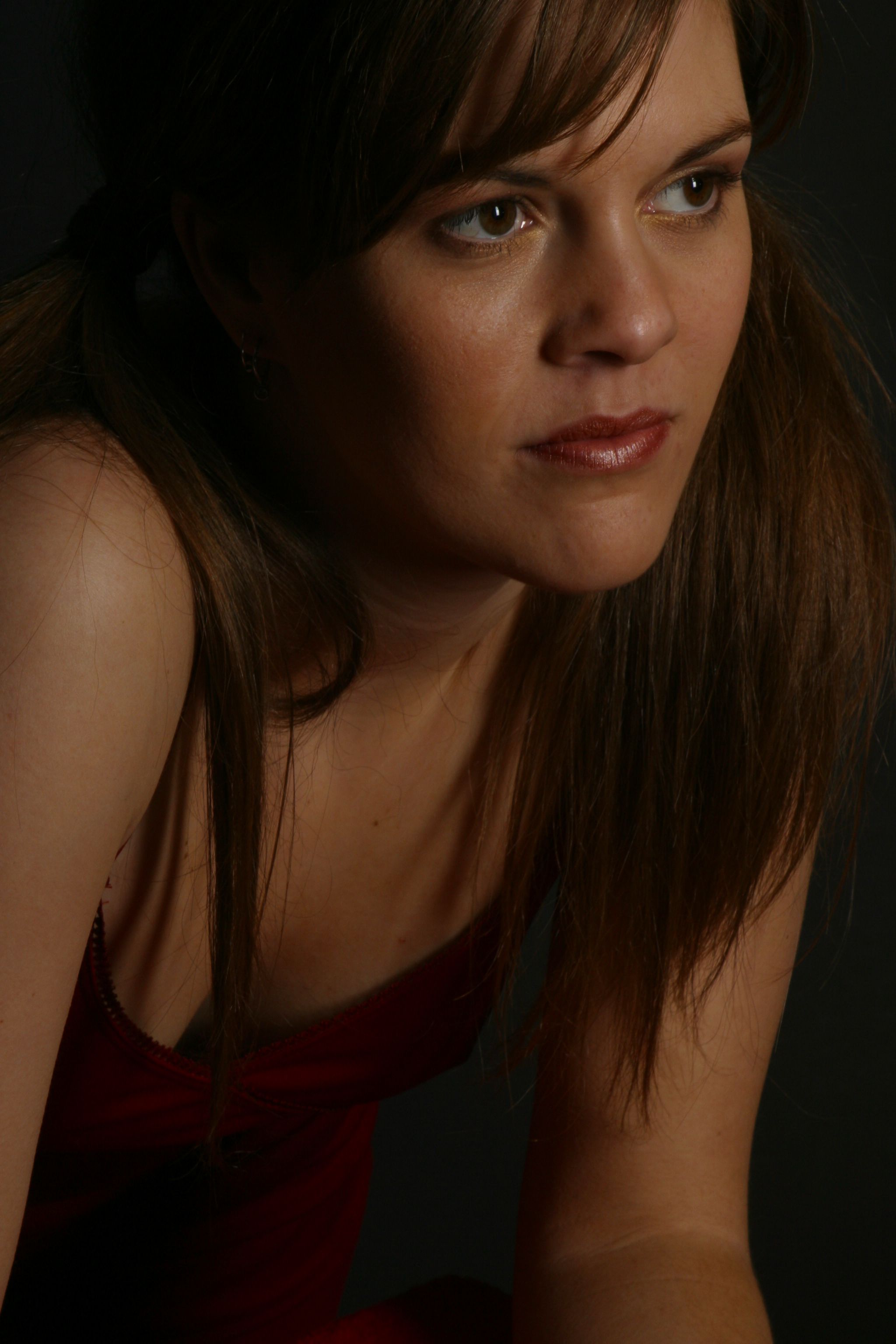Woman wearing a long, red sequined dress with spaghetti straps