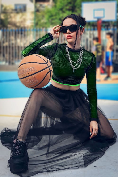 Woman in Sunglasses Squatting with Basketball Ball