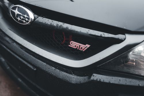 Free Detailed shot of a Subaru WRX STI front grille with logos, showcasing sleek design. Stock Photo