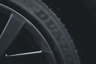 Detailed close-up of a Dunlop tire and rim showcasing its texture and brand text.