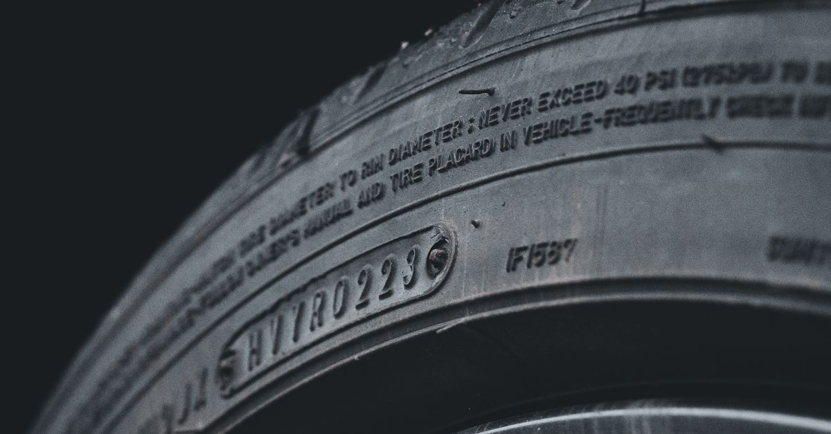 Detailed close-up image of a black car tire showcasing sidewall text and treads.
