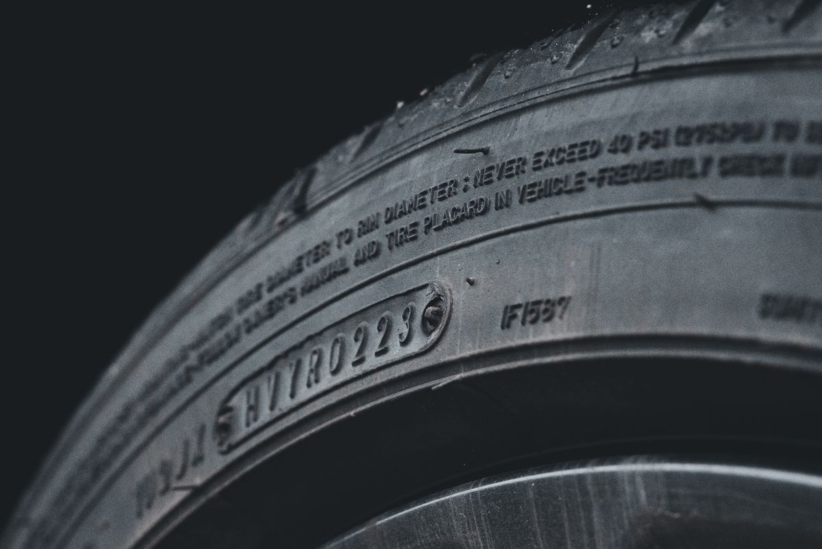 Close-up of a tire sidewall showing the DOT date code and maximum PSI stamping used to determine tire age