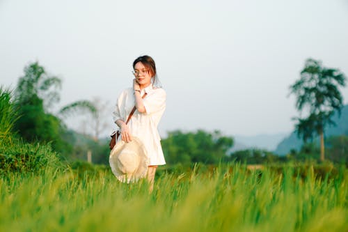 Young Woman on a Grass Field in the Countryside in Summer 