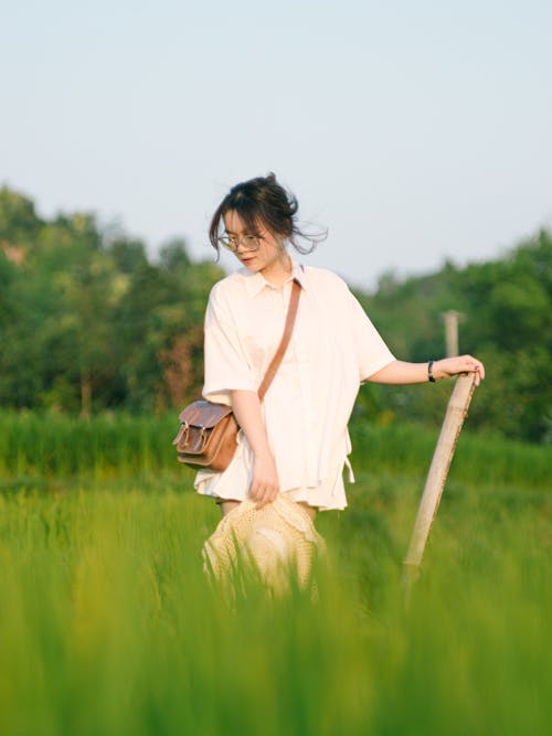 Young Woman on a Grass Field in the Countryside in Summer 