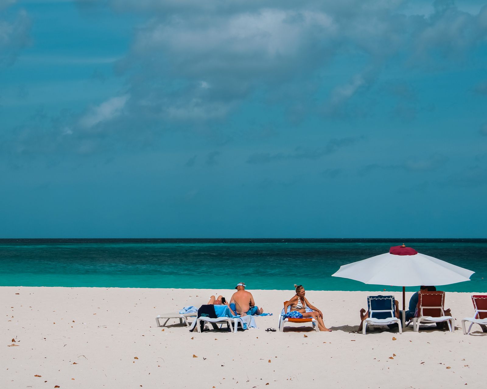 Catch Some Rays People Sunbathing on the Beach · Free Stock Photo