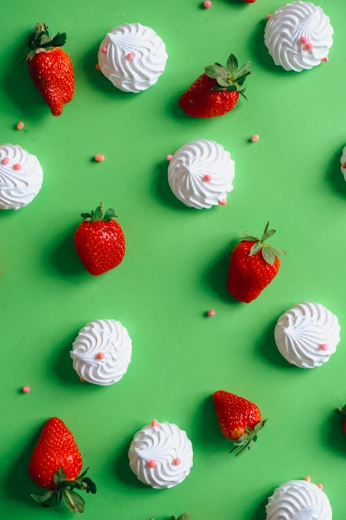 Strawberries and Meringues Lying on Green Back