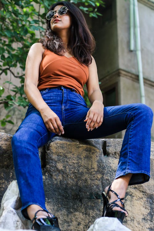 Free Woman Sitting on Rock Wearing Sunglasses Stock Photo