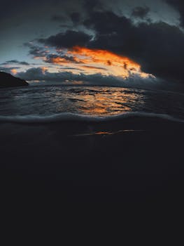 乌云缭绕的天空下，海浪之上，日落景象令人惊叹