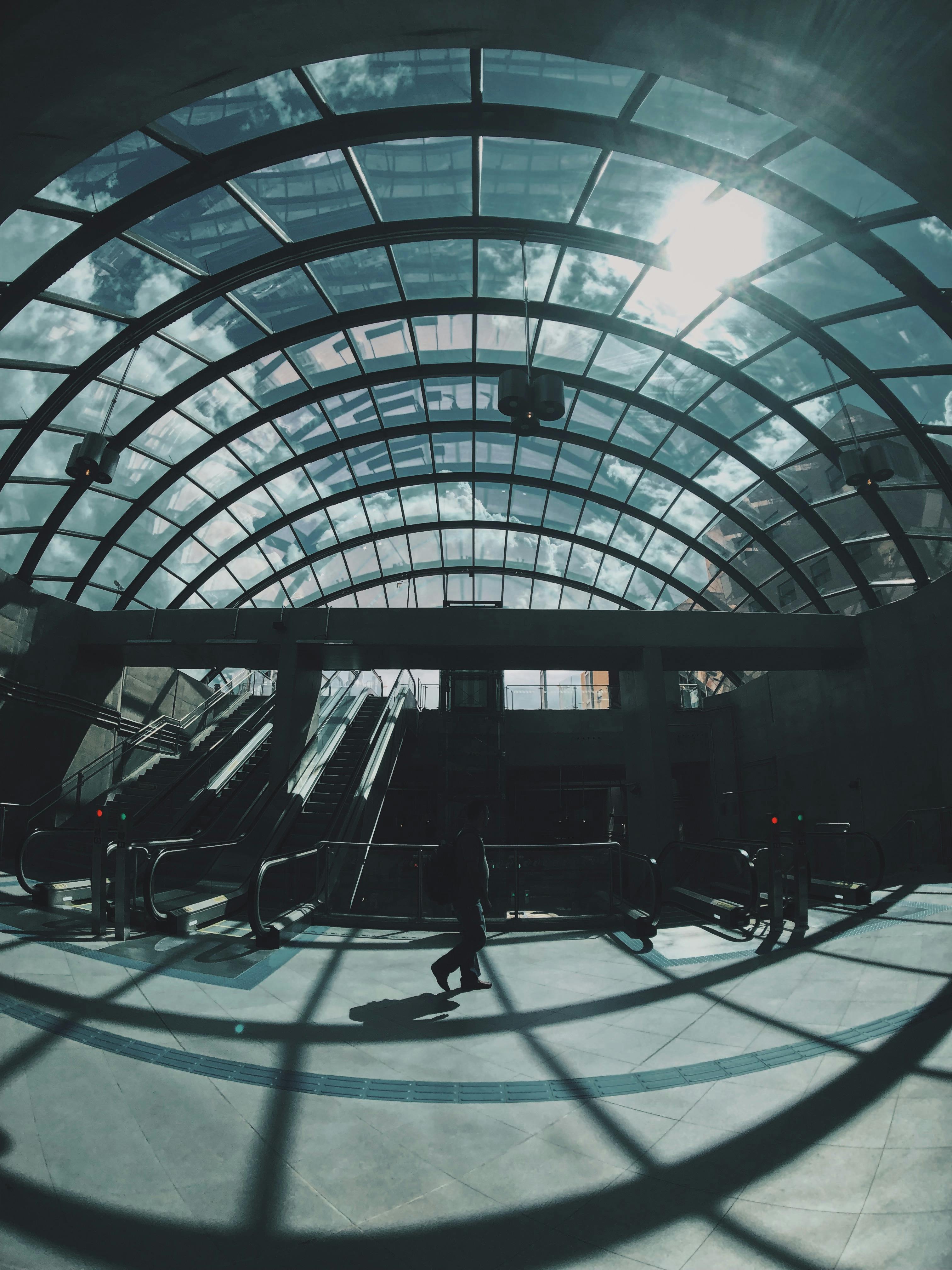 现代化的玻璃圆顶下，自动扶梯与引人注目的皮影戏共同描绘出一个繁忙的交通枢纽