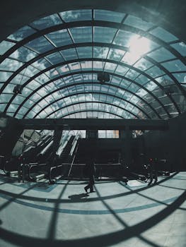 现代化的玻璃圆顶下，自动扶梯与引人注目的皮影戏共同描绘出一个繁忙的交通枢纽